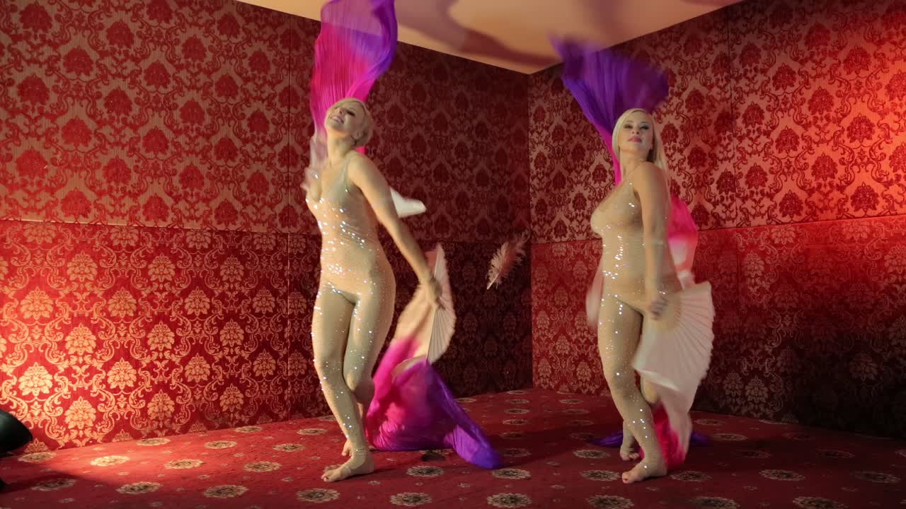 Two girls dancing with fans