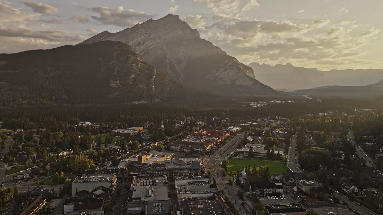 banff ab canada aerial v19 flyover - 아침 해가 뜨는 황금 시간 동안 숲이 인 계곡, 고풍스러운 도시 풍경 및 캐스케이드 산맥을 포착하는 도시 - mavic 3 pro cine로 촬영 - 2023 년 7 월