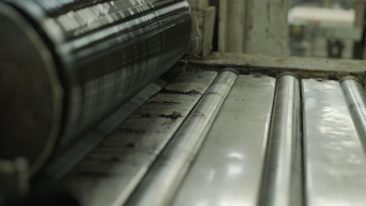 Detailní záběr na válec průmyslového stroje nanášející povlak na materiál
