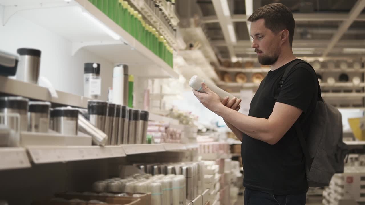 Mies ostaa keittiövälineitä supermarketissa