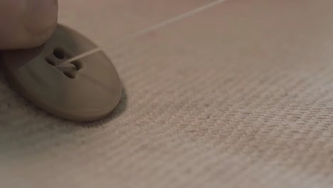 sewing a button onto cloth