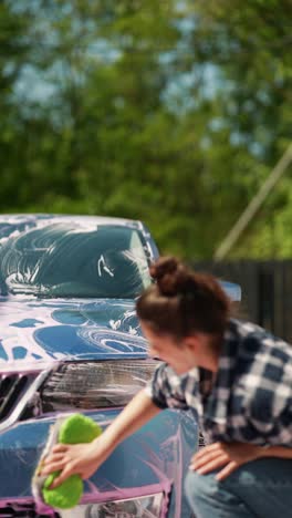 mujer lavando un coche azul