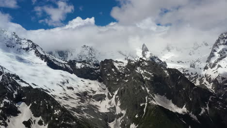 Flug-Durch-Bergwolken-über-Wunderschöne-Schneebedeckte-Gipfel-Von-Bergen-Und-Gletschern.