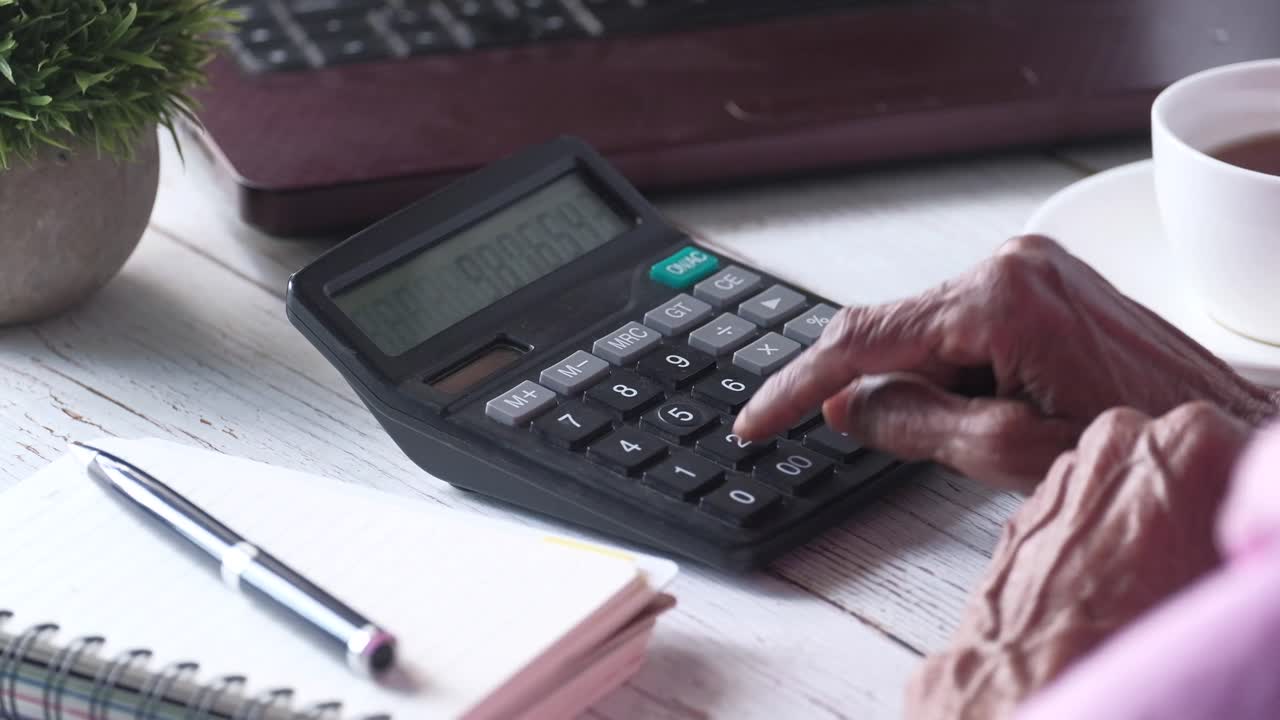 persona de edad avanzada que utiliza una calculadora