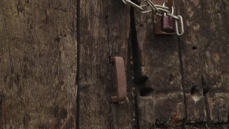 hacer zoom en un viejo mango de metal oxidado en una vieja puerta de roble