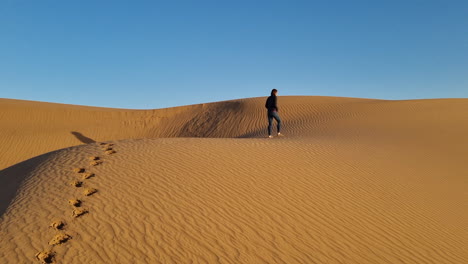 woman walking in the sand dunes of morocco