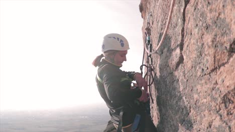 Escalador-Femenino-Colgando-De-Cuerdas-En-Una-Roca-Vertical