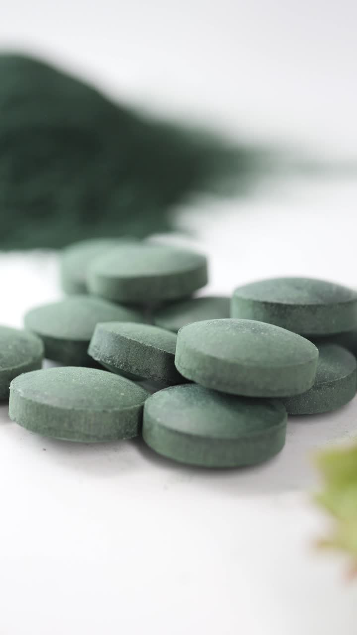 Close-Up of Green Health Supplement Pills and Powder