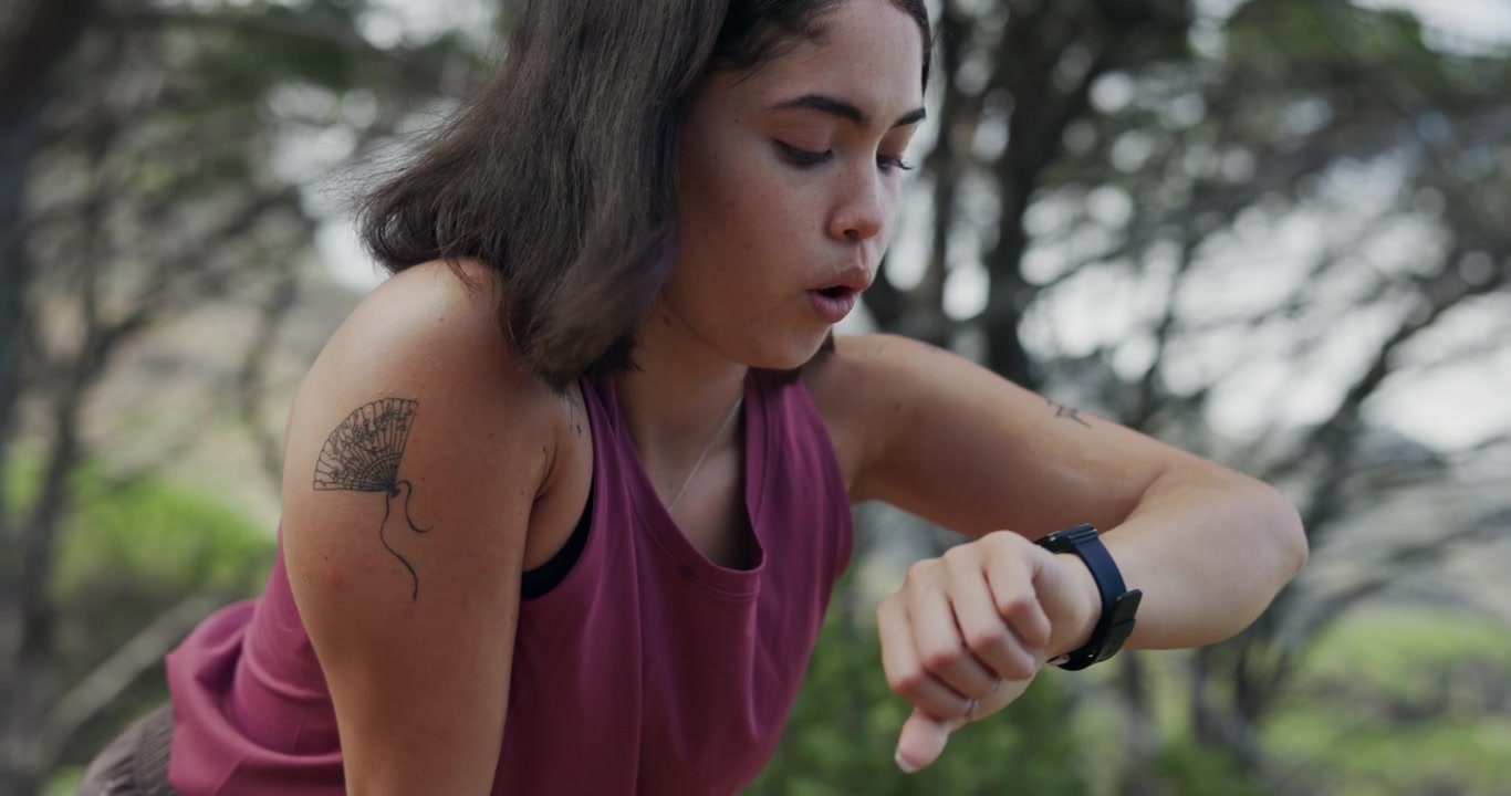 Young Woman Resting and Checking Smartwatch After Outdoor Run