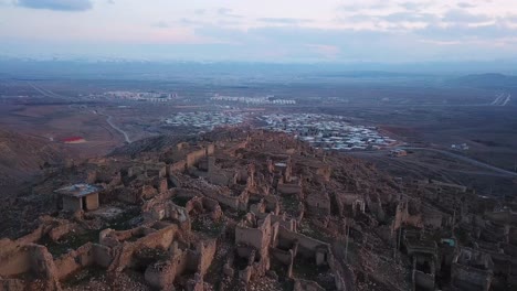 Paisaje-De-La-Cima-De-Una-Colina-Ruinas-Del-Castillo-Antiguo-Histórico-Antiguo-Pueblo-De-Ladrillo-Asentamiento-De-Pueblo-Roto-En-Verde-Natural-Amplia-Vista-En-La-Cima-De-La-Montaña-La-Vida-De-La-Ciudad-En-El-Fondo-Nublado-Cielo-Maravilloso-Noche