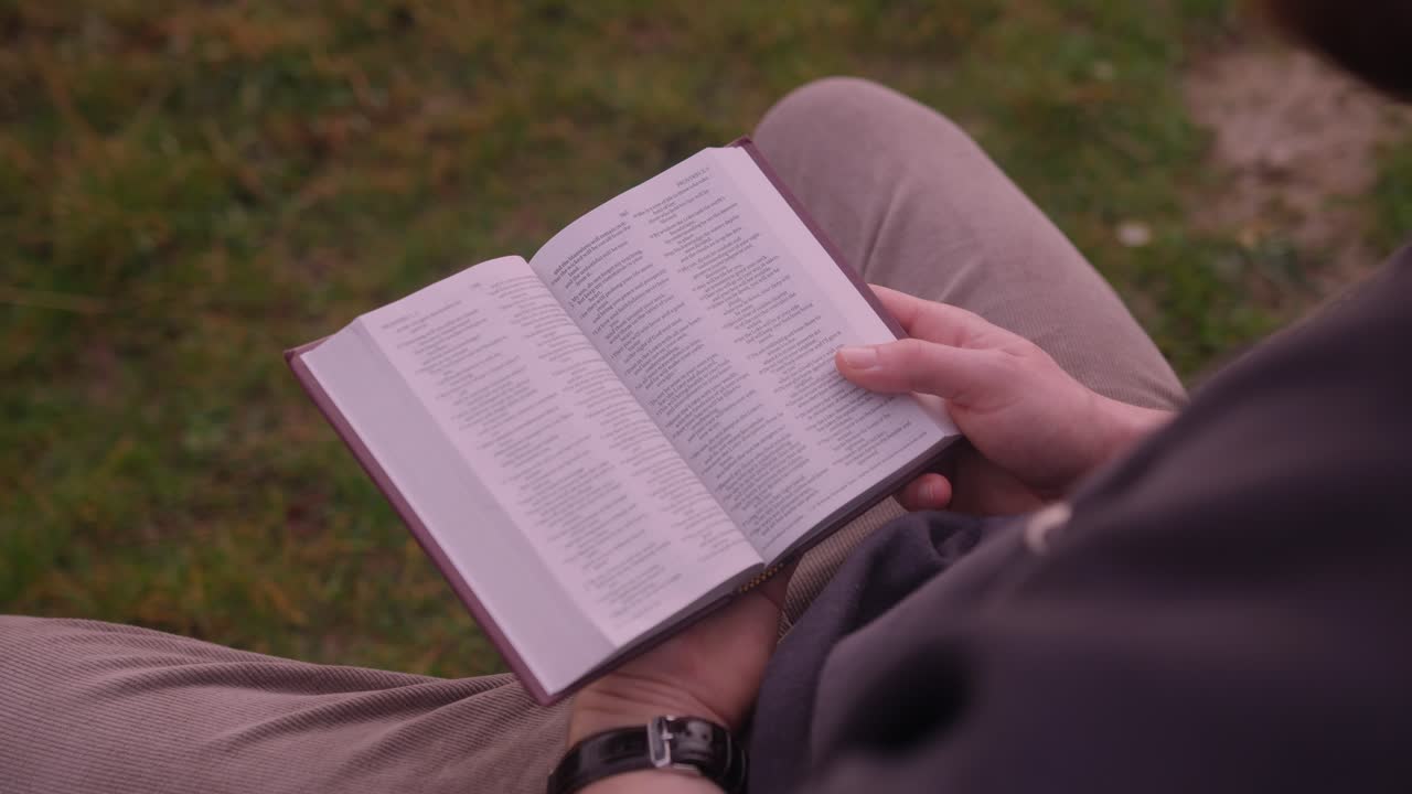 Devotional Moment: Caucasian Man Engrossed in Bible Study amidst Nature's Serenity