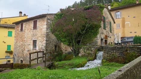 Árbol-Junto-Al-Arroyo-Con-Agua-Fresca-De-Manantial-Que-Fluye-En-Rasiglia,-Pintoresco-Pueblo-De-Umbría,-Italia