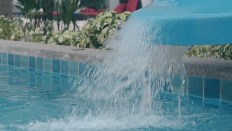 water falls down from slide into swimming pool closeup