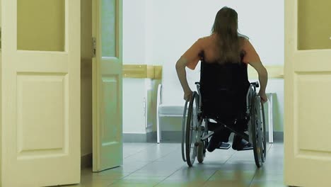 young guy drives through a hospital corridor on a wheelchair 2