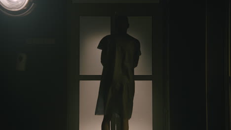 a bald man walks out the empty operation room