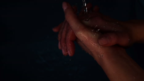 manos sumergiéndose en el agua negra