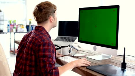 a young freelancer man using mouse and typing on keyboard