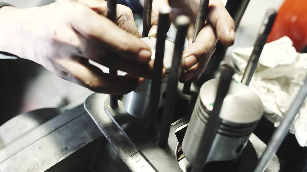 el mecánico repara el motor roto, el mecánico arregla el viejo motor de motocicleta, pone anillos en los pistones.