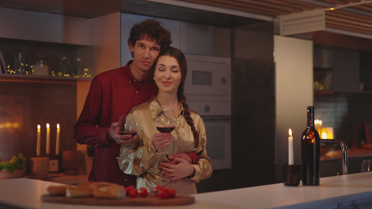 Couple enjoying a romantic evening with wine in their kitchen