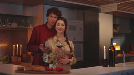 couple enjoying a romantic evening with wine in their kitchen
