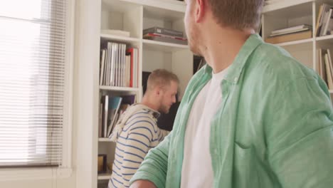 Caucasian-male-couple-in-social-distancing-at-home