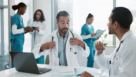 two doctors discussing a patient's medical record in a hospital office