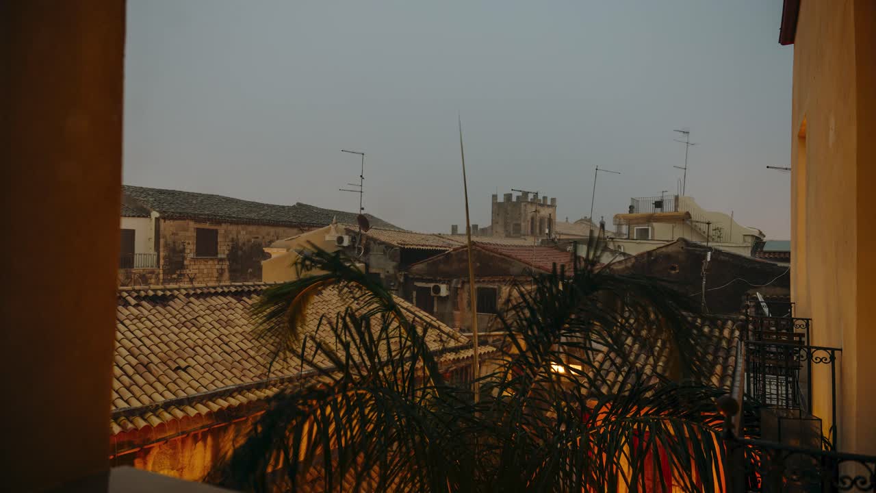 A view from a window to historic buildings in courtyard. Timelapse of Incoming thunderstorm in the evening. Ortigia island in Sicily.