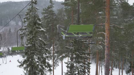 moving on a ski lift through a ski resort in the middle of trees and spruces and winter forest