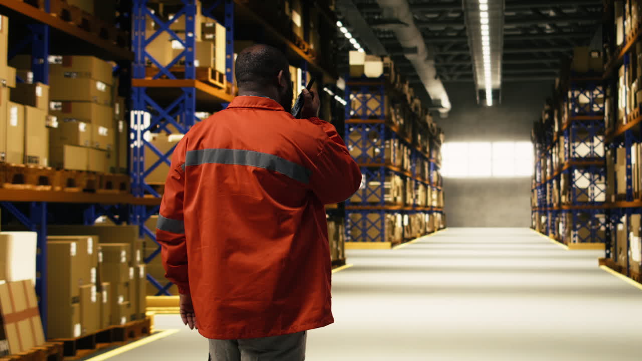 Black warehouse staff managing packages with walkie-talkie wireless signal