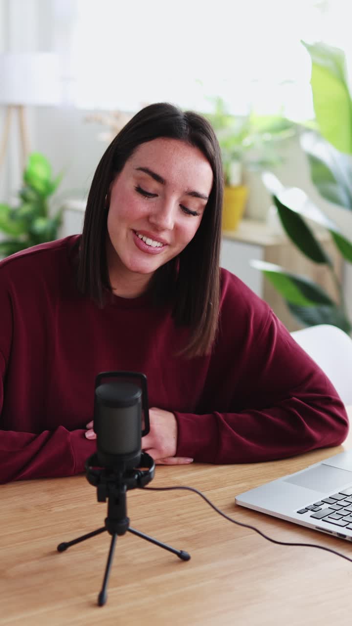 Joven feliz grabando podcast en su estudio casero