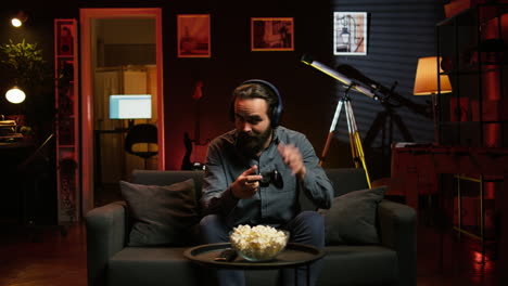 hombre sonriente poniendo auriculares para jugar videojuegos con sus compañeros de equipo