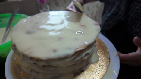 the process of applying the final layer of frosting to the cake