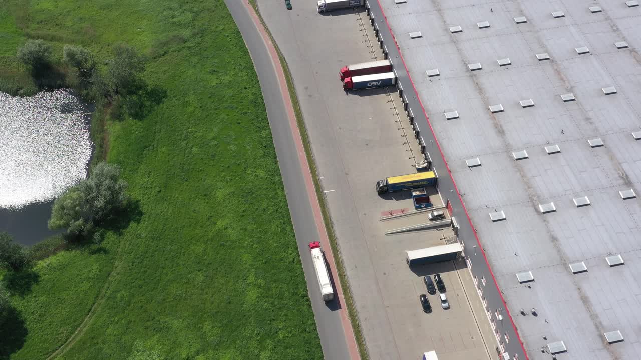 창고 단지를 떠나는 세미 트레일러가 부착된 트럭의 항공 샷