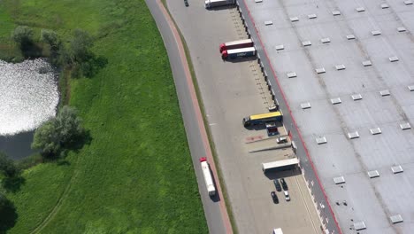 toma aérea de un camión con un semirremolque adjunto que sale del complejo de almacenes