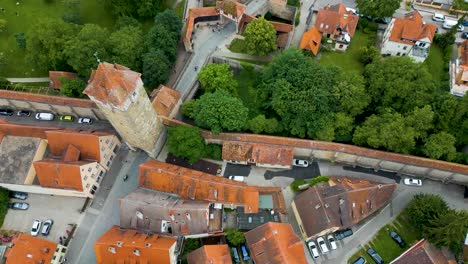 4k aerial drone video of a half-timbered hotel, historic tower gate, and moat around the walled city of rothenburg, germany