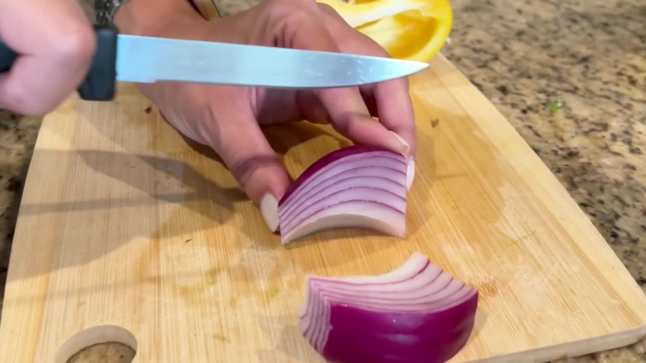 Slicing organic, fresh, red onions on a cutting board - slow motion