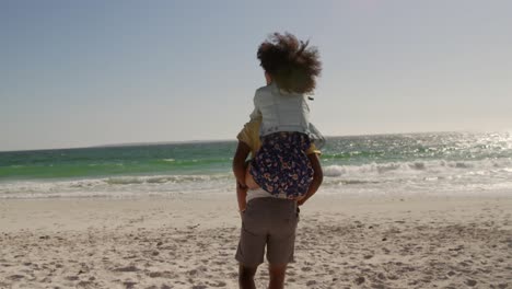 man giving piggyback ride to woman on the beach 4k