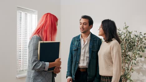 vendo um apartamento à venda, alugando para potenciais inquilinos casal falando no quarto com agente imobiliário, eles discutem fazendo perguntas brincando mulher aponta lugares na casa para os amantes