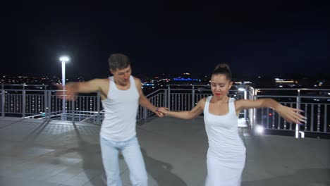 couple dancing on rooftop at night