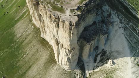 aerial view of a dramatic white cliff face with grass