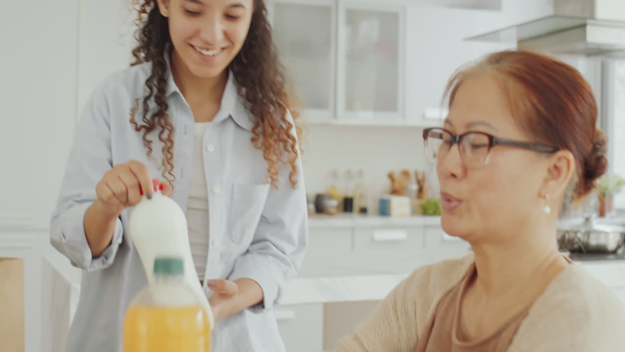 People holding bottles of orange juice and milk