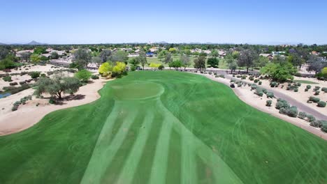 Empuje-Aéreo-Desde-La-Calle-Hasta-El-Green-Mientras-Un-Carro-De-Golf-Se-Mueve-A-Lo-Largo-Del-Camino-Del-Carro-Concepto-De-Scottsdale-Arizona:-Recaudación-De-Fondos,-Pliegues-De-Honor,-Caridad