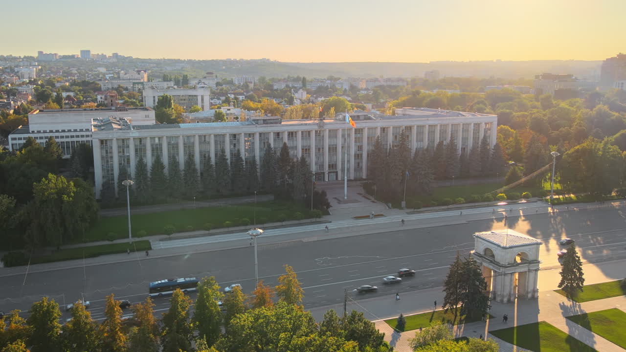 Aerial drone view of Chisinau downtown at sunset. Panorama view of Goverment building, Triumph Arch and central park, road with moving cars. Moldova