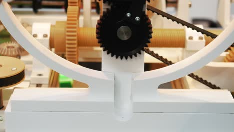 close-up of a mechanical model with gears and belts