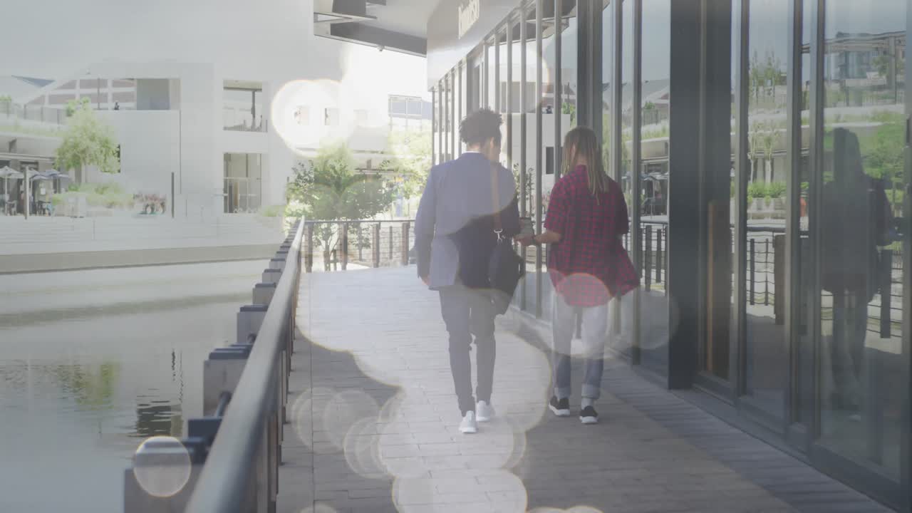animación de puntos de luz sobre dos hombres sonrientes caminando por la ciudad