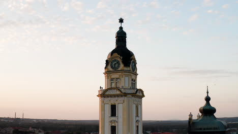 clock tower overlooking pcs city in hungary at sunrise -aerial