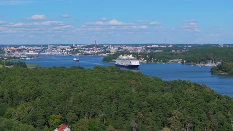 saga cruise ship spirit of adventure navigating narrow archipelago fairway in finland on departure. city in background. distant aerial front view.