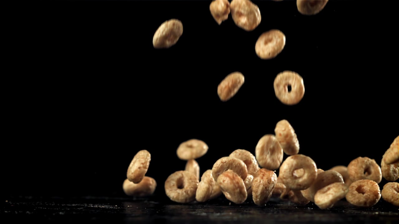 Golden Breakfast Cereal Rings Falling in Slow Motion