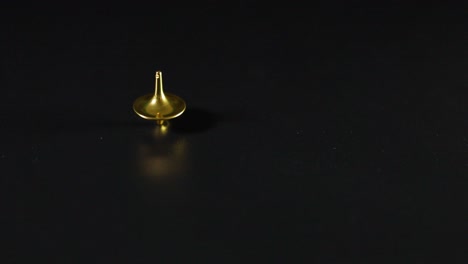 golden top spinning on a dark surface