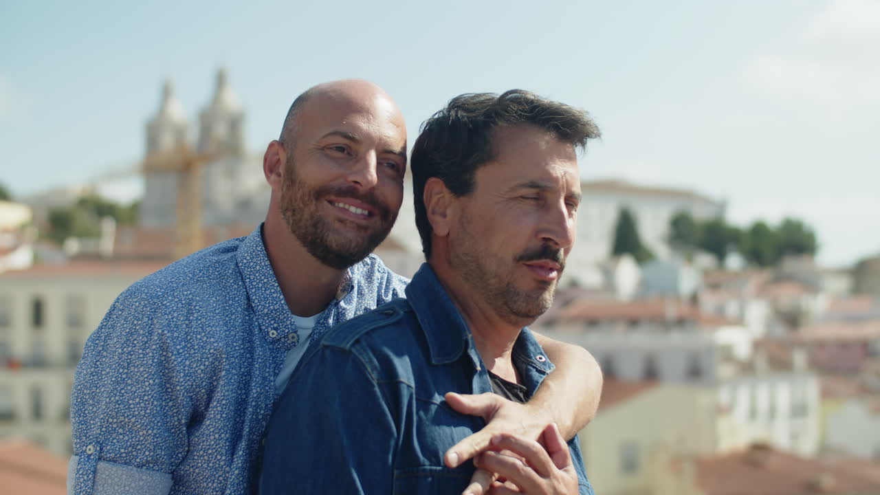 뒤에서 잘 생긴 대담한 게이 포옹 연인의 중간 샷